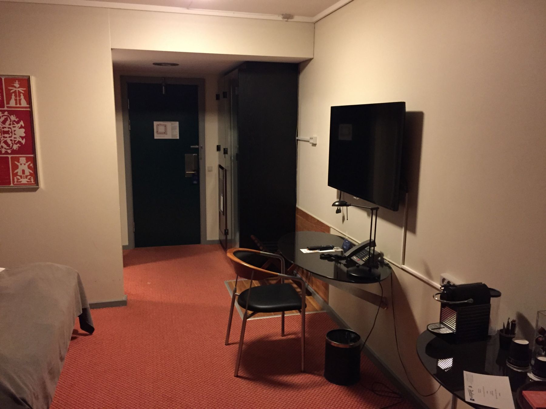 Skrivebordet med TV og inngangspartiet i bakgrunnen